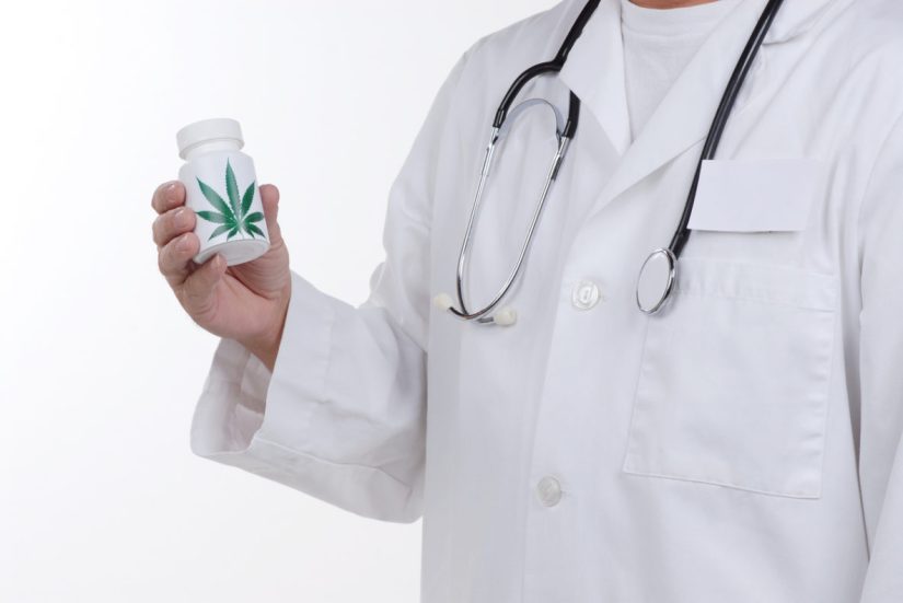 Torso of a doctor holding a bottle with a marijuana label